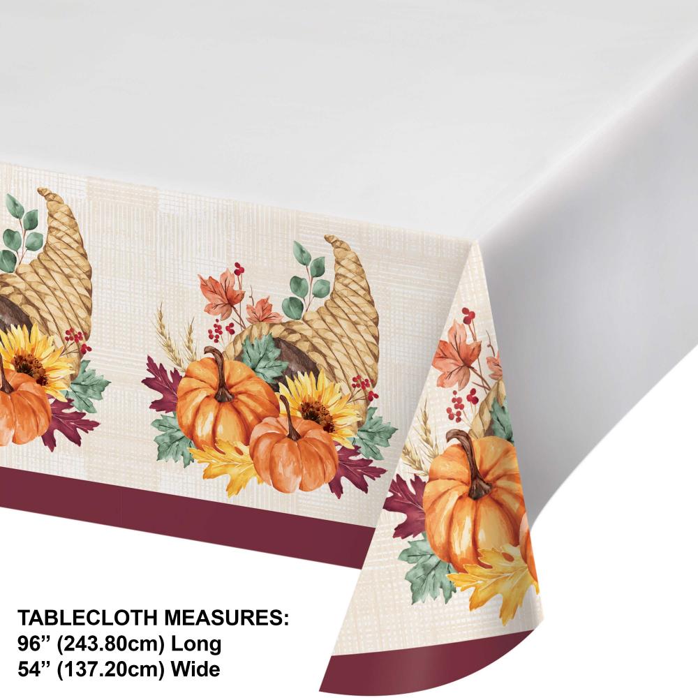 Decorative tablecloth with autumnal design featuring pumpkins and leaves on a white background.